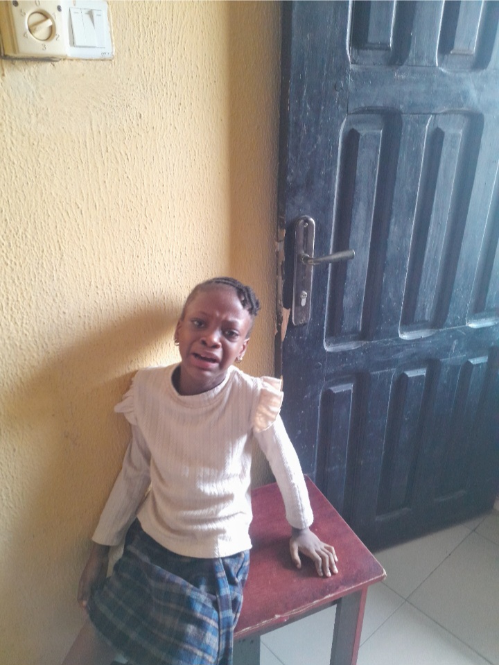 strong-willed child in a doorway wearing a white top